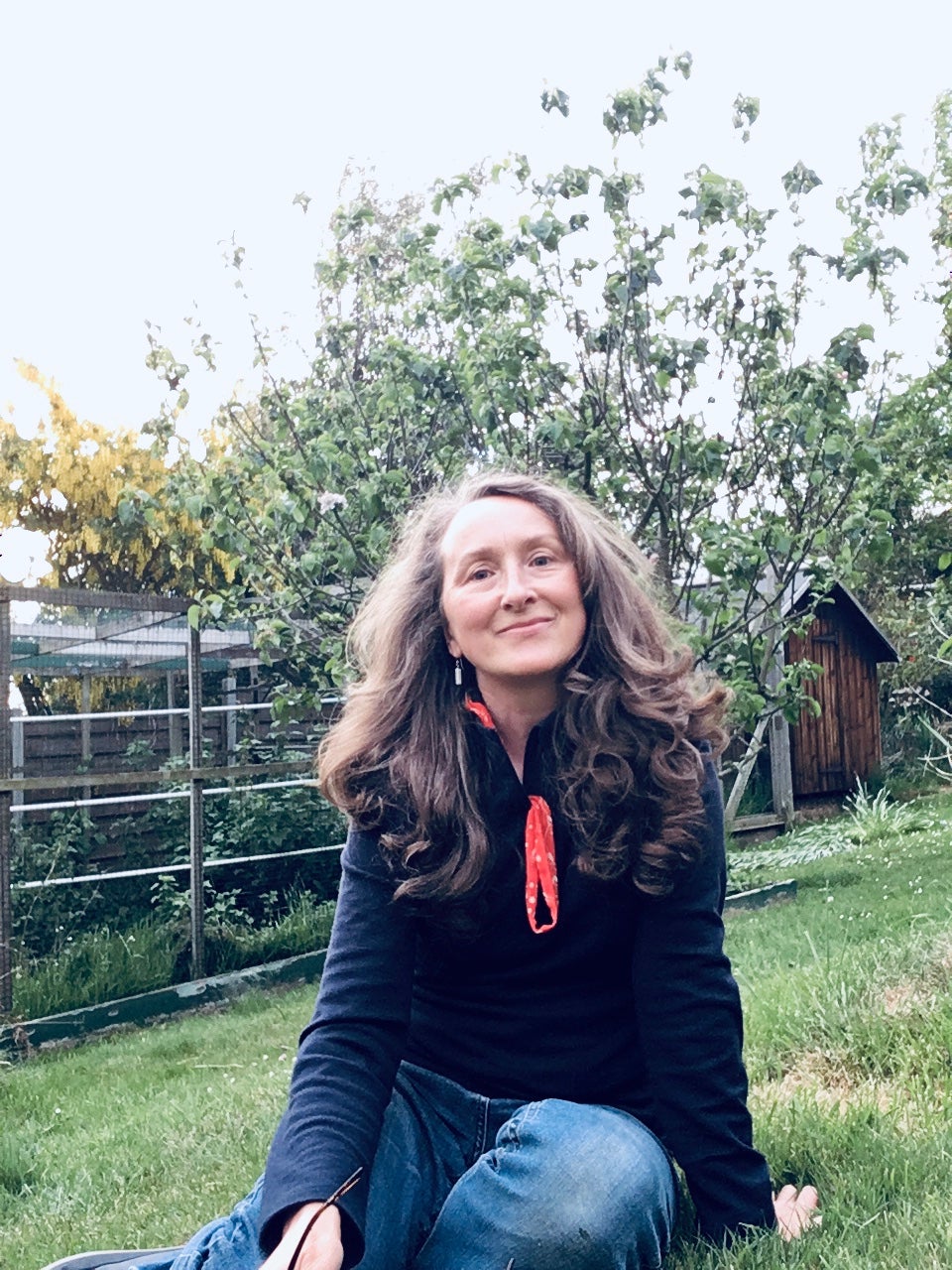 Lois Williams is a white woman with shoulder-length blond hair standing outdoors near trees