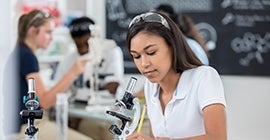 Student looking through microscope in lab