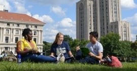 Students sitting on lawn outside Cathedral of Learning