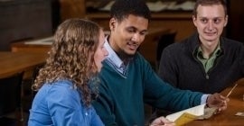 3 students discussing paper